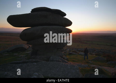 Mann in Silhouette Ansehen genießen den Sonnenuntergang neben der Cheesewring Granit Stack Felsformation auf Stowes Hill Bodmin Moor Ca Stockfoto