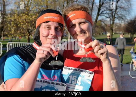 Glasgow, Schottland. 8. November 2014. Läufer in der Movember, Mens Gesundheit Bewusstsein Spaß laufen in Glasgow Green. Stockfoto