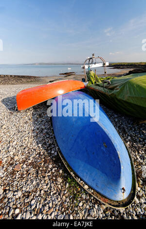 Umgedrehten orange und blaue kleine Boote liegen auf einem Kiesstrand Stockfoto