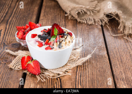 Erdbeer-Joghurt in einer kleinen Schüssel auf hölzernen Hintergrund Stockfoto