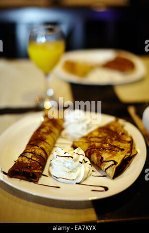 Nahaufnahme von Pfannkuchen mit Schokolade Sirup und Sahne in einem restaurant Stockfoto