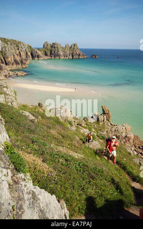 Klippe Blick im Sommer Blick hinunter auf Paare, die sich Cliffpath von Porthcurno Strand bei Ebbe mit Blick über die Bucht Stockfoto