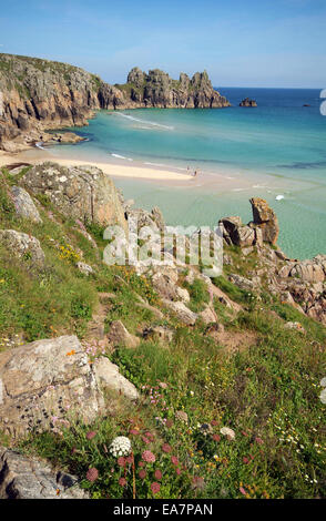 Klippe Blick im Sommer Blick von Porcella Punkt auf Menschen paddeln am Treen Strand von Porthcurno Strand bei Ebbe Witz Stockfoto