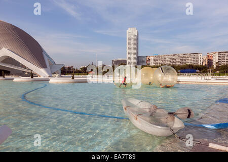 Kinder spielen in riesigen schwimmenden transparenten Kugeln auf dem See in der Ciudad de Las Artes y Las Ciencias, Valenci Stockfoto