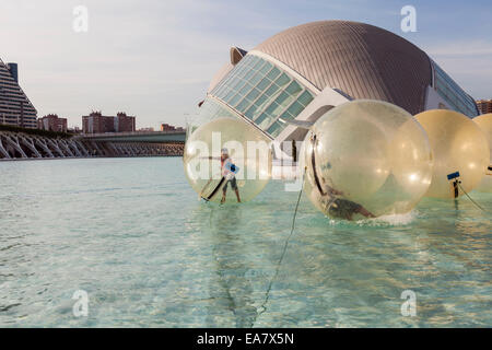 Kinder spielen in riesigen schwimmenden transparenten Kugeln auf dem See in der Ciudad de Las Artes y Las Ciencias, Valenci Stockfoto