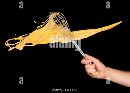 Isolierte Schuss Knickeier mit Ei Peitsche auf schwarzem Hintergrund Stockfoto