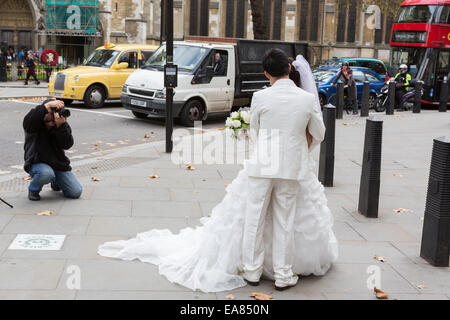 Ein chinesisches Ehepaar haben Hochzeitsfotos genommen außerhalb der Westminster Abbey in London, England, UK Stockfoto