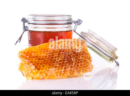 Studioaufnahme von Honig im Glas und Waben isoliert auf weißem Hintergrund Stockfoto