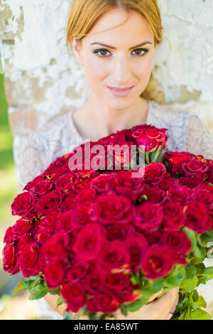 Junge Frau mit roten Rosen Stockfoto