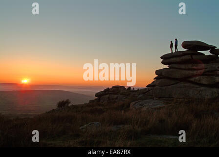Paar auf Stowes Hill Felsformation genießen den Sonnenuntergang Schergen Bodmin Moor Caradon South East Cornwall Süden W stehen Stockfoto