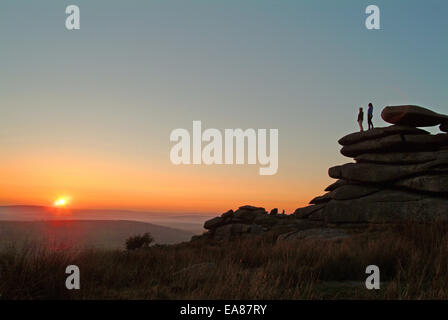 Paar auf Stowes Hill Felsformation genießen den Sonnenuntergang Schergen Bodmin Moor Caradon South East Cornwall Süden W stehen Stockfoto