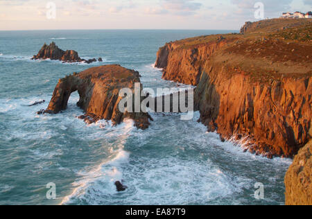 Blick über Zawn Wells bei Sonnenuntergang zu den felsigen Inseln Enys Dodnan und The bewaffneten Ritter & Carn Greeb Klippen mit dem Lands End Stockfoto