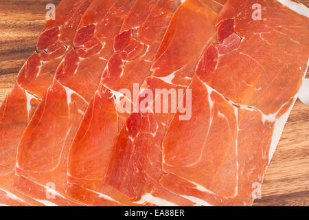 Spanischer Jamon Iberico in Scheiben geschnitten, auf hölzernen Hintergrund Stockfoto