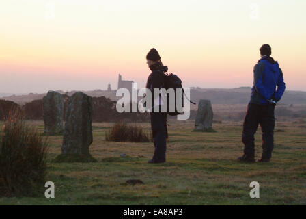 Zwei Wanderer Sonnenuntergang an die Hurlers Stone Circle auf Bodmin Moor an Schergen Caradon South East Cornwall Südwestengland Stockfoto