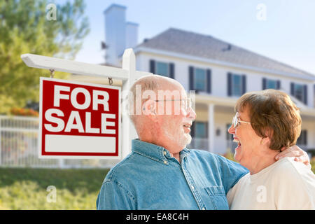 Gerne älteres Paar vor Verkauf Immobilien Zeichen und Haus. Stockfoto