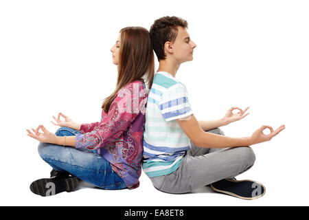 Jugendliche Freunde oder Klassenkameraden sitzen Rücken an Rücken in Meditationshaltung yoga Stockfoto