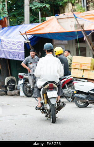 Mann auf Roller, so dass eine Lieferung an Dong Xuang Markt in Hanois Altstadt Stockfoto