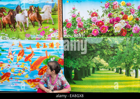 Verkäuferin auf Straße vor Poster zum Verkauf feiert Chinesisches Neujahr, Chinatown-Viertel von Bangkok, Thailand, Asien. Stockfoto