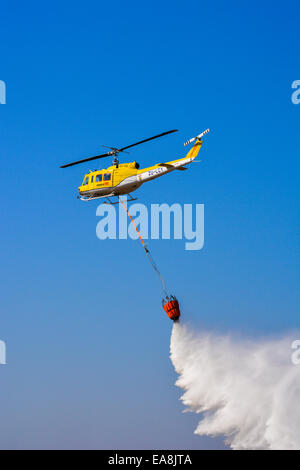 Arbeiten auf Feuer Hubschrauber Fallenlassen einer Belastung von Wasser auf das Lowveld Air Show Stockfoto