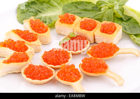 Roter Kaviar in Gebäck und Salat auf Teller. Stockfoto