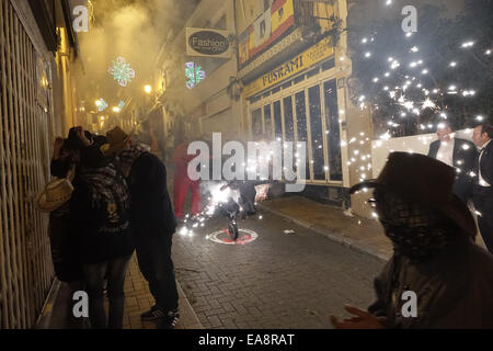 Die beweglichen Feuer, oder pyrotechnische Correfoc spektakuläre fand um 2 Uhr morgens, durch die Altstadt mit einer Trommel band folgenden Wicklung und schlug einen hektischen Rhythmus, die penya Mitglieder Feuerwerk auf Stöcke und Spindeln entzünden, sprühen die Menschen in der Masse, mit einigen Zeichen jagen Menschen mit einem Stier oder Dragon spuckende Funken. am Ende der Show gibt es ein Feuerwerk auf der Landzunge mit Blick auf Benidorm. Stockfoto