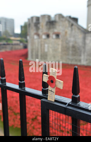 Tower of London, London, UK. 9. November 2014. Ein einzelnes Holzkreuz befestigt, die Geländer auf dem Tower of London. Die Massen füllen Sie den Bereich rund um den Tower of London die 888.246 Keramik Mohnblumen betrachten, die den Burggraben zu füllen. Bildnachweis: Matthew Chattle/Alamy Live-Nachrichten Stockfoto