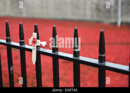 Tower of London, London, UK. 9. November 2014. Ein einzelnes Holzkreuz befestigt, die Geländer auf dem Tower of London. Die Massen füllen Sie den Bereich rund um den Tower of London die 888.246 Keramik Mohnblumen betrachten, die den Burggraben zu füllen. Bildnachweis: Matthew Chattle/Alamy Live-Nachrichten Stockfoto