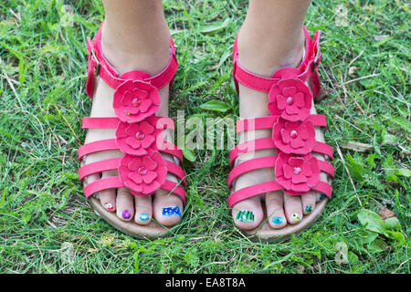 Kinderfüße in roten Sandalen und lackierten Fußnägel Stockfoto