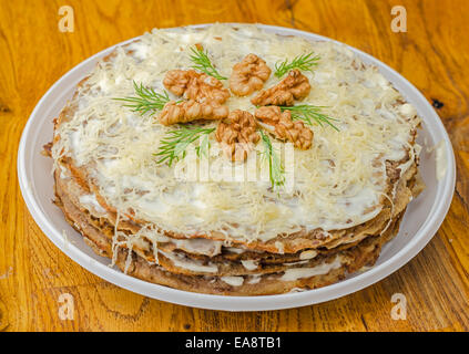 Leber-Kuchen mit Knoblauch, Dillsauce und Walnüsse in die weiße Platte auf Holztisch. Stockfoto