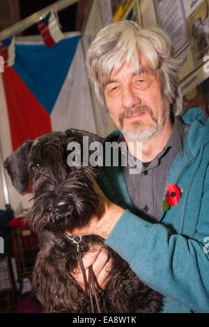 Earls Court, London, 9. November 2014. Doglovers, Züchter und Petcare Unternehmen aus ganz Großbritannien konvergieren im Earls Court Exhibition Centre für die 19. entdecken Hunde-Ausstellung, organisiert von der Kennel Club. Mehr als 200 Rassen sind auf der Messe vertreten, wo Veranstalter ändern möchten, öffentliche Wahrnehmung über die Hunde, sie wählen, so dass sie der Eigentümer Lebensstil, anstatt für ihr Aussehen gewählt wird. Bild: Cesky Terrier Annie posiert mit ihrem Besitzer und Cesky Terrier Züchter Steve Fewings aus Surrey. Bildnachweis: Paul Davey/Alamy Live-Nachrichten Stockfoto