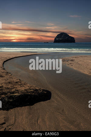 Trebarwith Strand in der Nähe von Tintagel, Cornwall, mit Gull Rock Silhouette. Simulierten Sonnenuntergang. Stockfoto