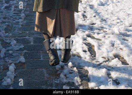 Frau zu Fuß auf der eisigen Straße Stockfoto