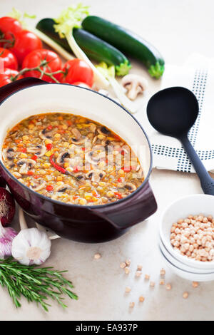Suppe mit Kichererbsen, Pilzen und Gemüse in Gusseisen Pfanne Stockfoto
