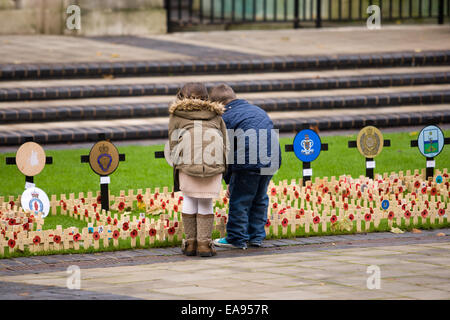 Belfast, Nordirland. 9. November 2014. Zwei Kleinkinder, Blick auf die hölzerne Kreuze am Cenotaph in Belfast zum Gedenken an den nationalen Tag des Gedenkens Stockfoto