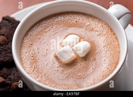Nahaufnahme von einer cremigen Tasse heiße Schokolade mit Marshmallows und Schokoladenkekse. Stockfoto