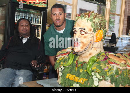 College-Football-Spieler und NFL Top Entwurf Perspektive stellt Anthony Barr eine lebensgroße Essen-Statue aus U-Bahn frisches Gemüse Optionen gemacht. Zur Verfügung ist auch Eric LeGrand, ehemaliger Fußballspieler defensive Tackle, dienen als Barrs Eingezogenes, bei Subway restaurant Stockfoto