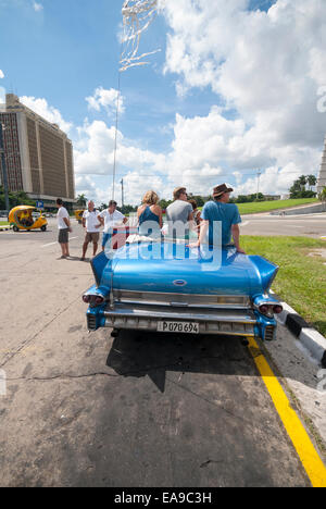 Touristen sitzen auf der Rückseite des Jahrgangs 1958 Cadillac Fleetwood Cabrio am Platz der Revolution in Havanna Kuba Stockfoto