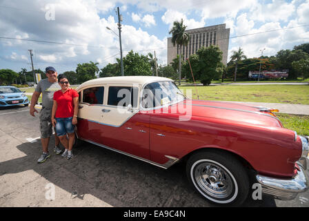 Ein Fahrer und Tour Guide warten durch ihre klassische 1955 Pontiac auf Revolution Platz Plaza De La Revolución in der Innenstadt von Havanna Kuba Stockfoto