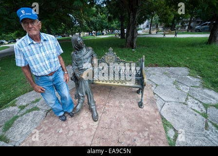 Ein Wachmann, der it-job hat ist es, die John Lennon-Skulptur für Touristen am Parque John Lennon in Havanna Kuba Brille aufsetzen Stockfoto