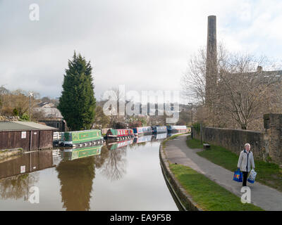 Rot Grün und blau bemalte Kanal schmale Boote vertäut auf einer Kurve in Leeds und Liverpool Kanal in Skipton West Yorkshire. Stockfoto