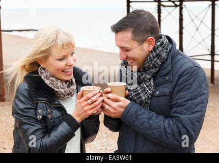 Ein paar genießt einen Tag an der britischen Küste in Brighton in warme Winterkleidung Stockfoto