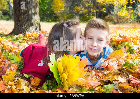 Fallen. Bruder und Schwester mit Blättern im Herbst park Stockfoto