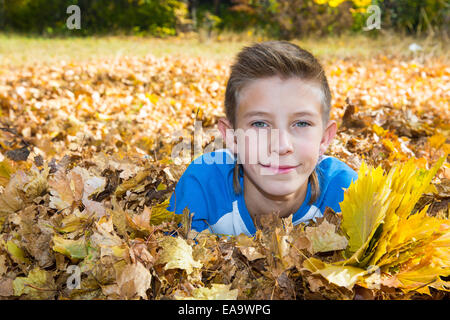 Fallen. junge Teenager mit Blätter im Herbst park Stockfoto