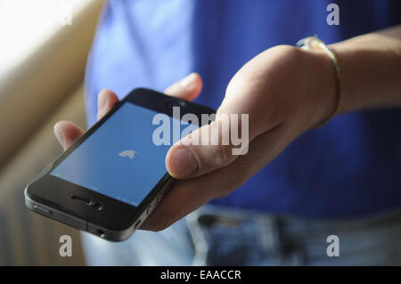 Teenage Boy Holding An Apple Iphone 4 Stockfoto