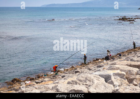 Tanger, Marokko - 22. März 2014: Arabische Fischer mit einem langen Stangen Stand auf den Atlantik Küste in der Bucht von Tanger, Mor Stockfoto