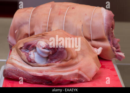 Gemeinsames Schweinefleisch auf einem roten Schneidebrett rohes Fleisch Stockfoto