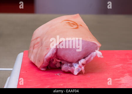 Gemeinsames Schweinefleisch auf einem roten Schneidebrett rohes Fleisch Stockfoto