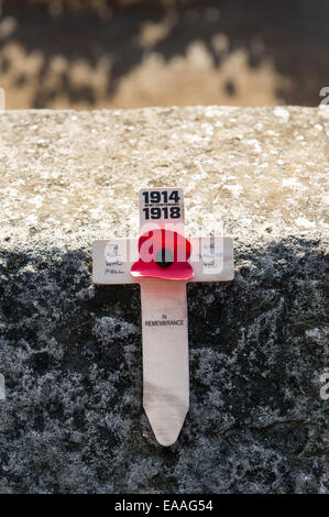 London, UK. 10. November 2014. Ein einzelnes Jubiläum Holzkreuz mit einem roten Mohn Platz an einer Wand im Tower von London Massen strömten um zu sehen, die 888,246 Keramik Erinnerung Mohnblumen in den Graben rund um den Tower of London in Erinnerung an jene Soldaten getötet Credit: Rena Pearl/Alamy Live News Stockfoto