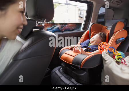 Eine Mutter und ihr junges Baby junge in einem Auto. Stockfoto