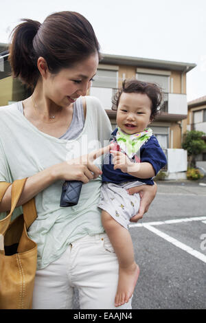 Mutter trägt ihr Baby Boy. Stockfoto